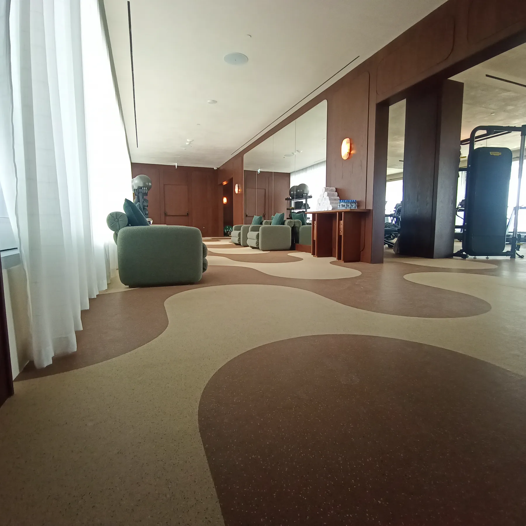 Custom organic-shaped carpet inlay in a Doha hotel spa relaxation area with green upholstered seating