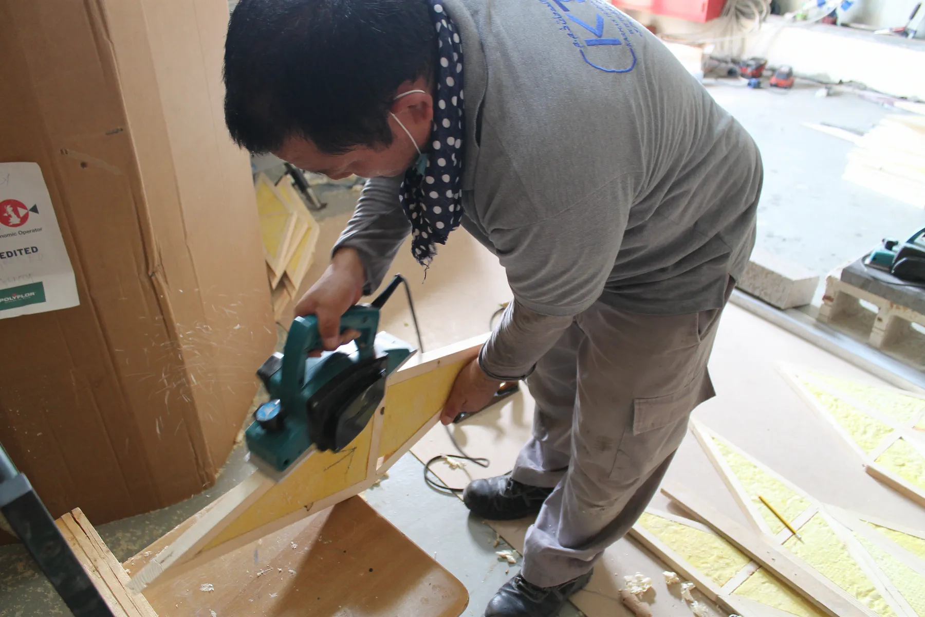 KTS craftsman planing a timber batten for an acoustic panel frame inside the KTS Acoustic Studio production facility in Doha