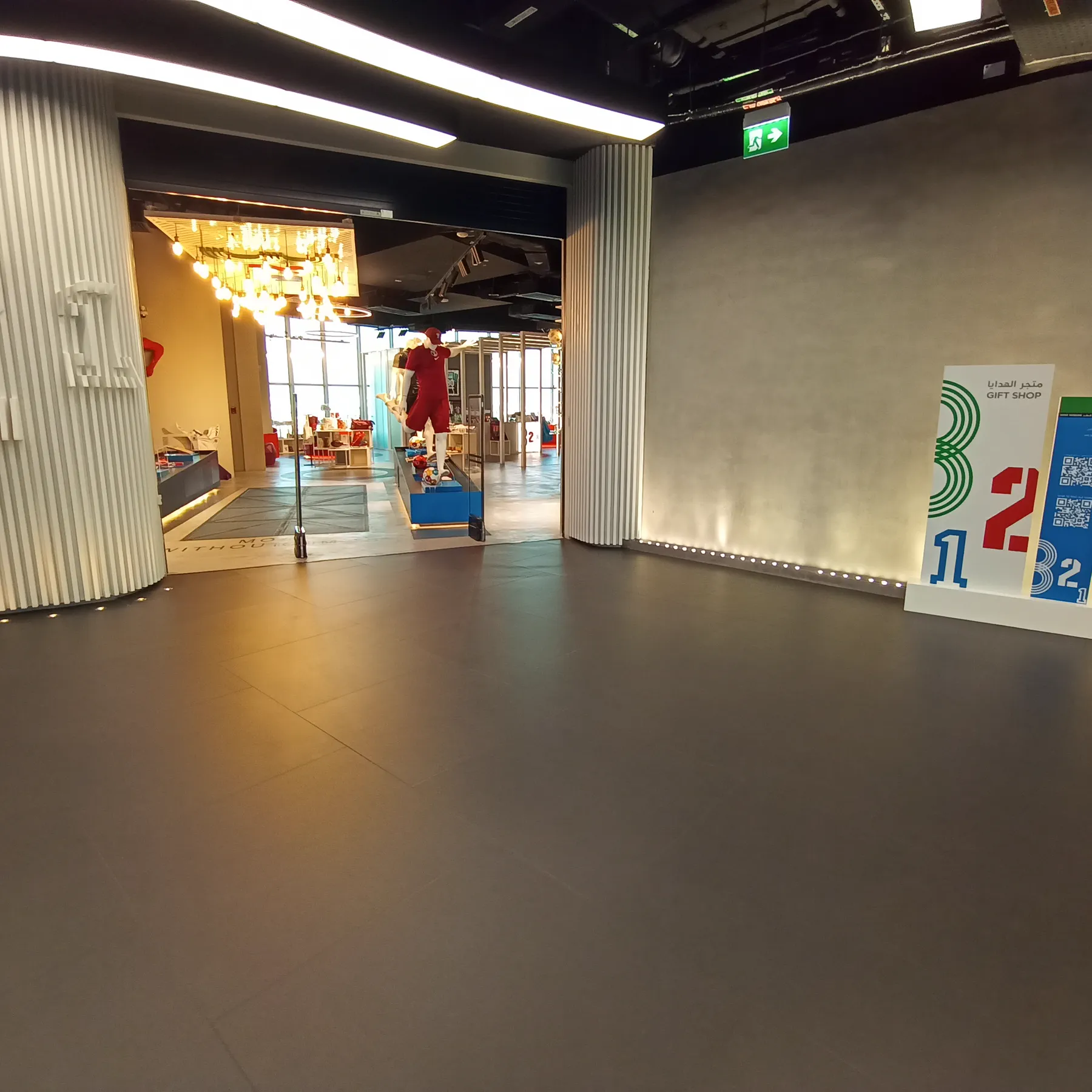 Seamless grey rubber flooring at a museum gallery entrance in Doha with a ribbed metal feature wall